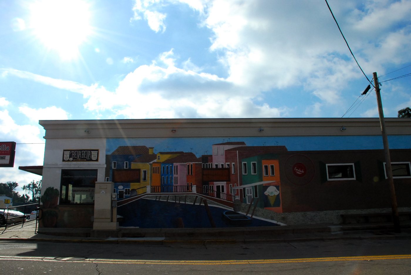 Brightly painted storefronts on the block, under a blue sky